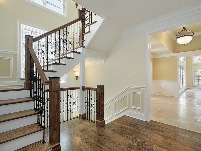 A curved staircase with wood treads and iron spindles, the stair and railing work most flooring crews subcontract out